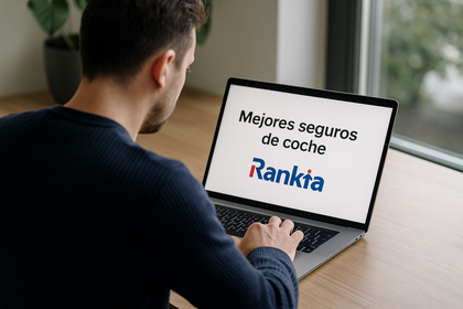 Fotografía real de una persona sentada frente a un ordenador con la pantalla mostrando el texto “Mejores seguros de coche” y el logo de Rankia.