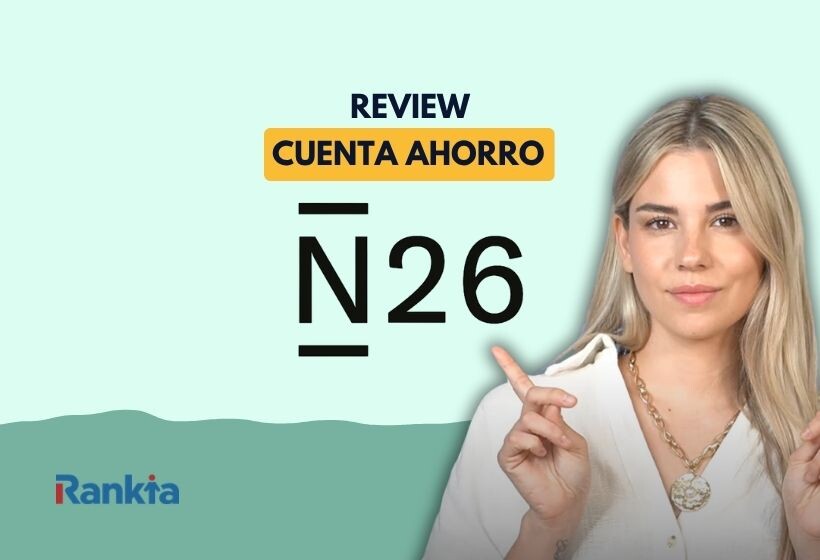 Fondo verde menta y una ola en tono verde azulado en la parte inferior. En el centro, el texto "REVIEW" en azul marino y, debajo, "CUENTA AHORRO" en azul sobre un rectángulo naranja/amarillo redondeado. Bajo eso, el logo "N26" en letras grandes negras con rayas superior e inferior. A la derecha, una mujer joven de pelo rubio, con blazer blanco y collar dorado, señalando hacia el logo con el dedo índice. Abajo a la izquierda, el logo de Rankia.
